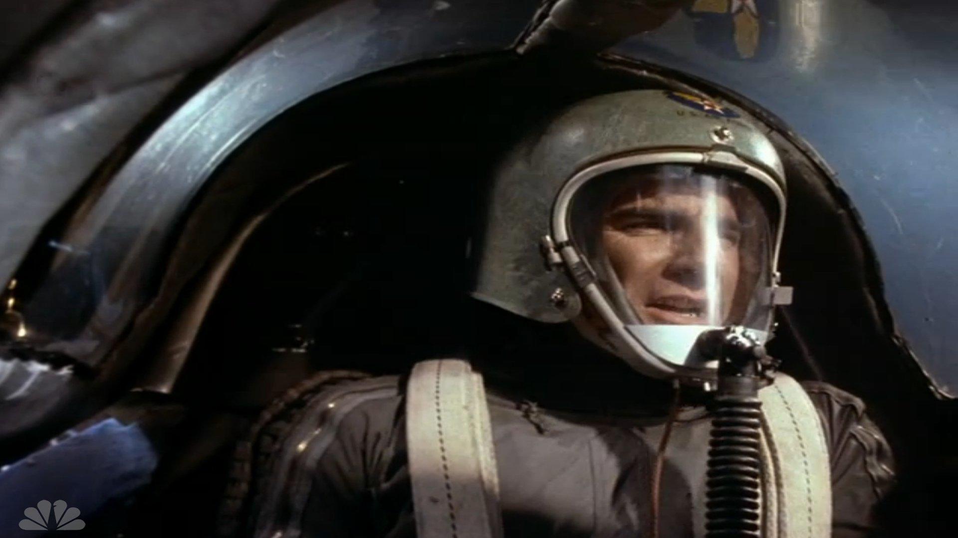 quantum-leap-zagubiony-w-czasie-2 | film.org.pl Pilot in a fighter jet cockpit wearing a helmet with visor and oxygen mask, looking ahead during flight.