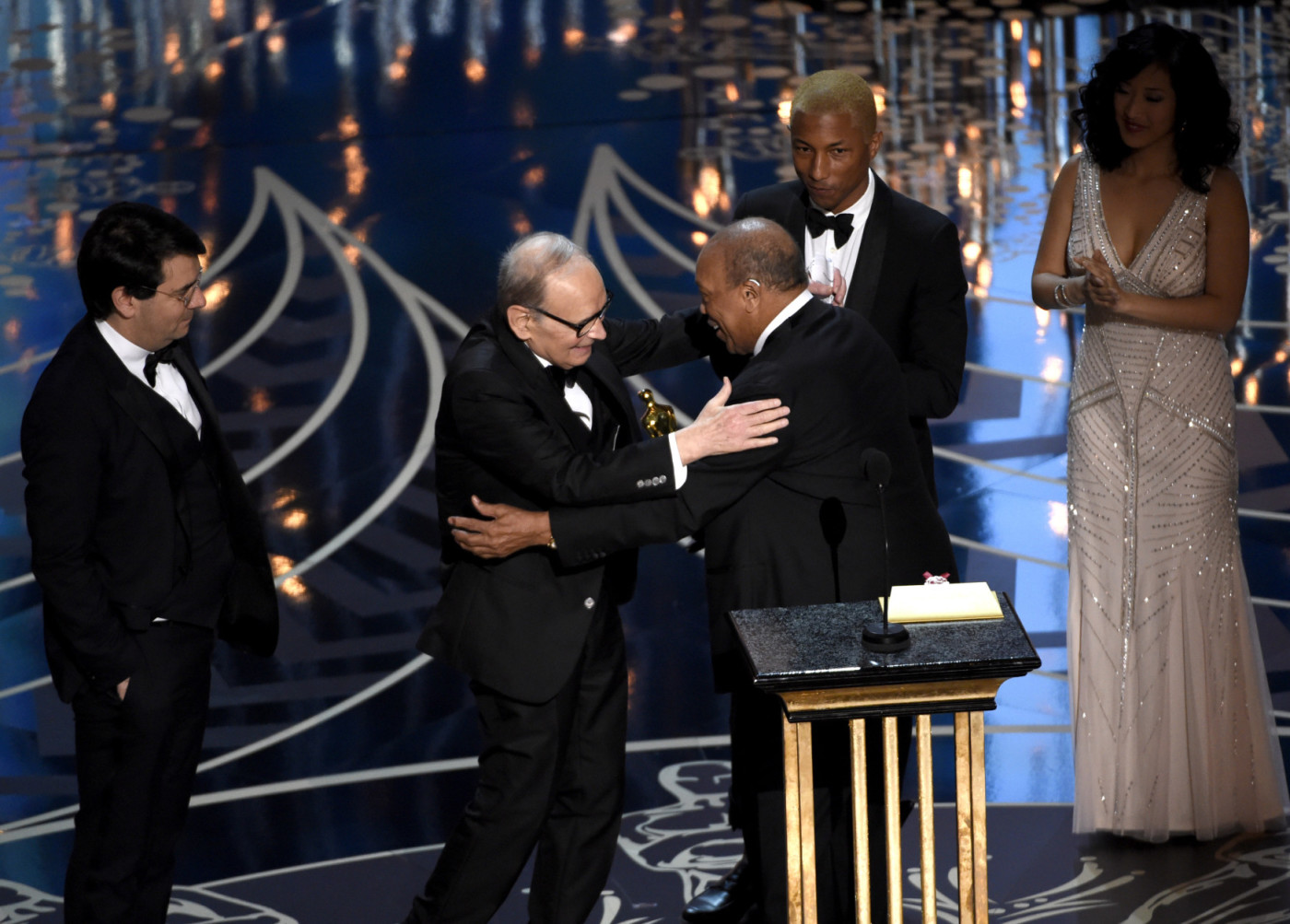 Quincy Jones, center, and Pharell Williams, right, present Ennio Morricone with the award for best original score for The Hateful Eight at the Oscars on Sunday, Feb. 28, 2016, at the Dolby Theatre in Los Angeles. (Photo by Chris Pizzello/Invision/AP)