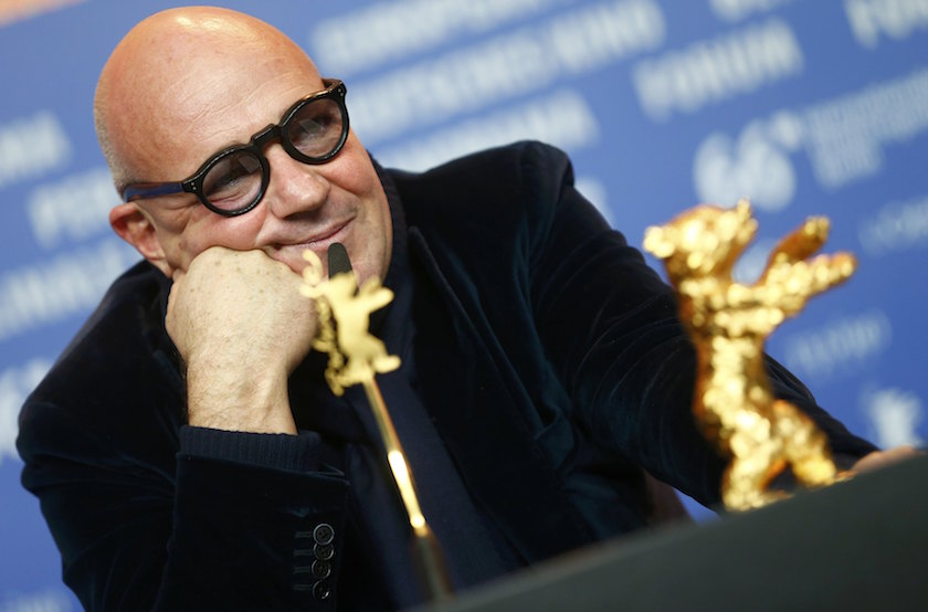 Director Gianfranco Rosi sits next to the Golden Bear award for the Best Film at a news conference after the awards ceremony of the 66th Berlinale International Film Festival in Berlin