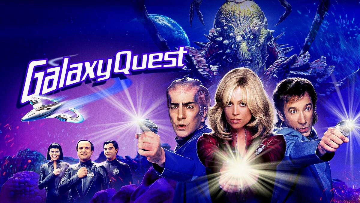 Galaxy Quest movie poster featuring the main cast in blue uniforms, each projecting glowing beams in a vivid space setting with alien backdrop.