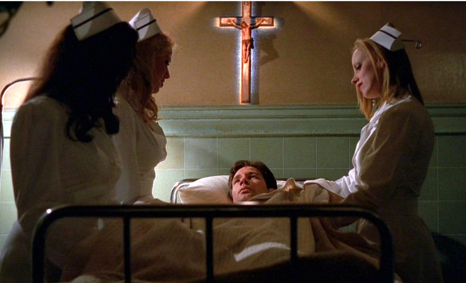 x-files-kill-switch-2 | film.org.pl Man in a hospital bed surrounded by three nurses in white uniforms; a crucifix is on the wall behind them.