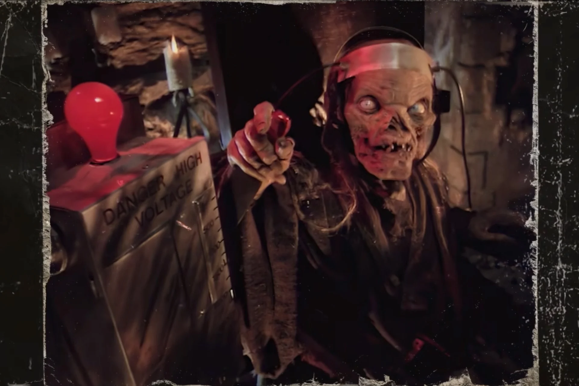 A zombie-like creature with a helmet and headset in a dark, spooky room, pointing toward the viewer from beside a danger-rated box with a red balloon nearby.