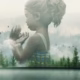 Man standing in a gallery viewing a large double-exposure mural: a girl’s semi-transparent profile blending into a forest landscape.