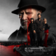 Dramatic poster: a stern man in a black fedora looms over three stylish allies at a harbor, with a red vertical stripe highlight behind them ready for a thriller.