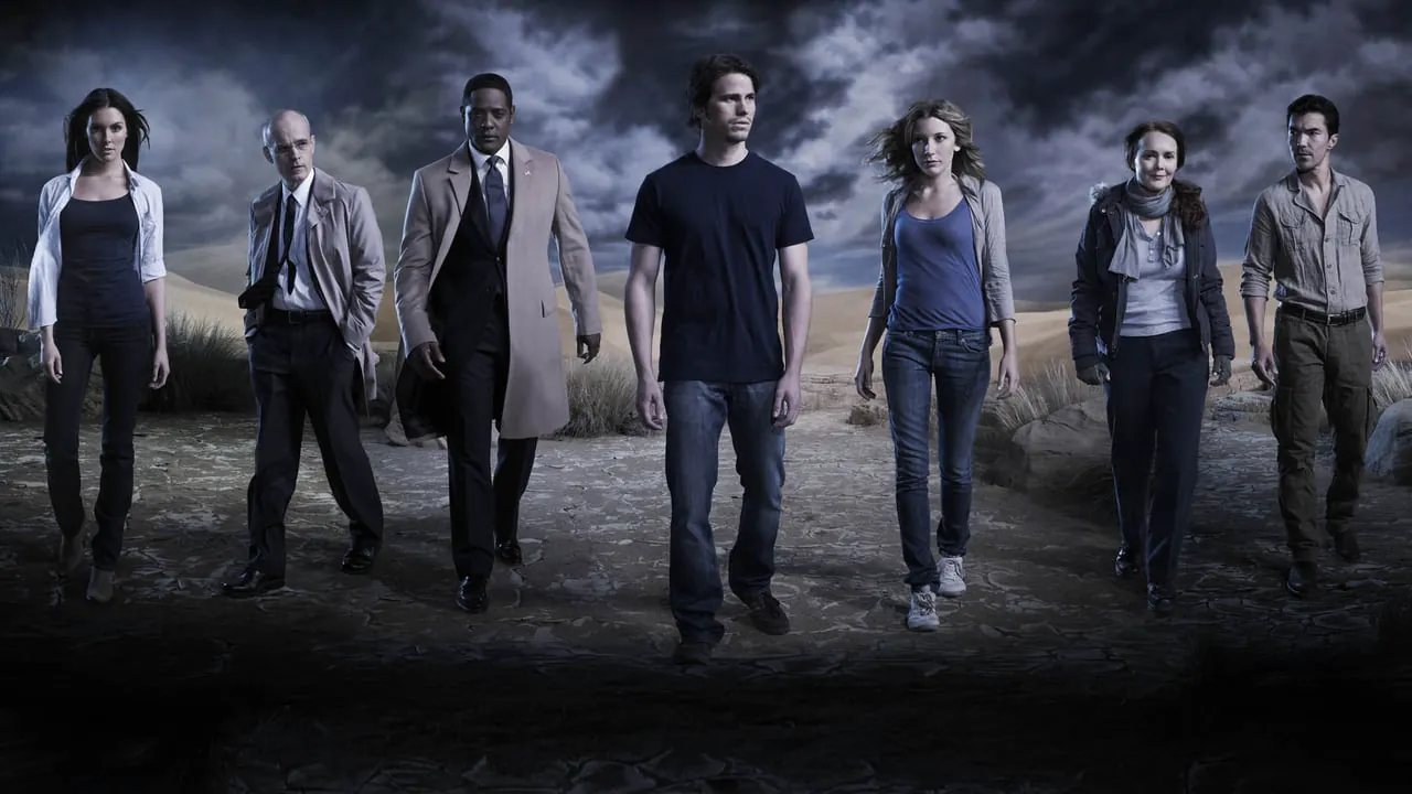 the-event-2 | film.org.pl Group of eight adults walking toward the camera across a cracked desert landscape under dark stormy skies.