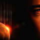 Sci-fi image: close-up of a man's face on the right with a red eye, Mars at left with a bright sun glow in space backdrop.