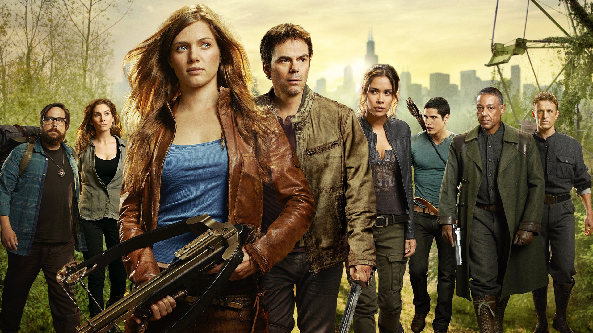 Revolution-cover | film.org.pl Group of seven survivors walking toward the camera in a post‑apocalyptic setting, led by a woman with a large crossbow strapped to her chest.