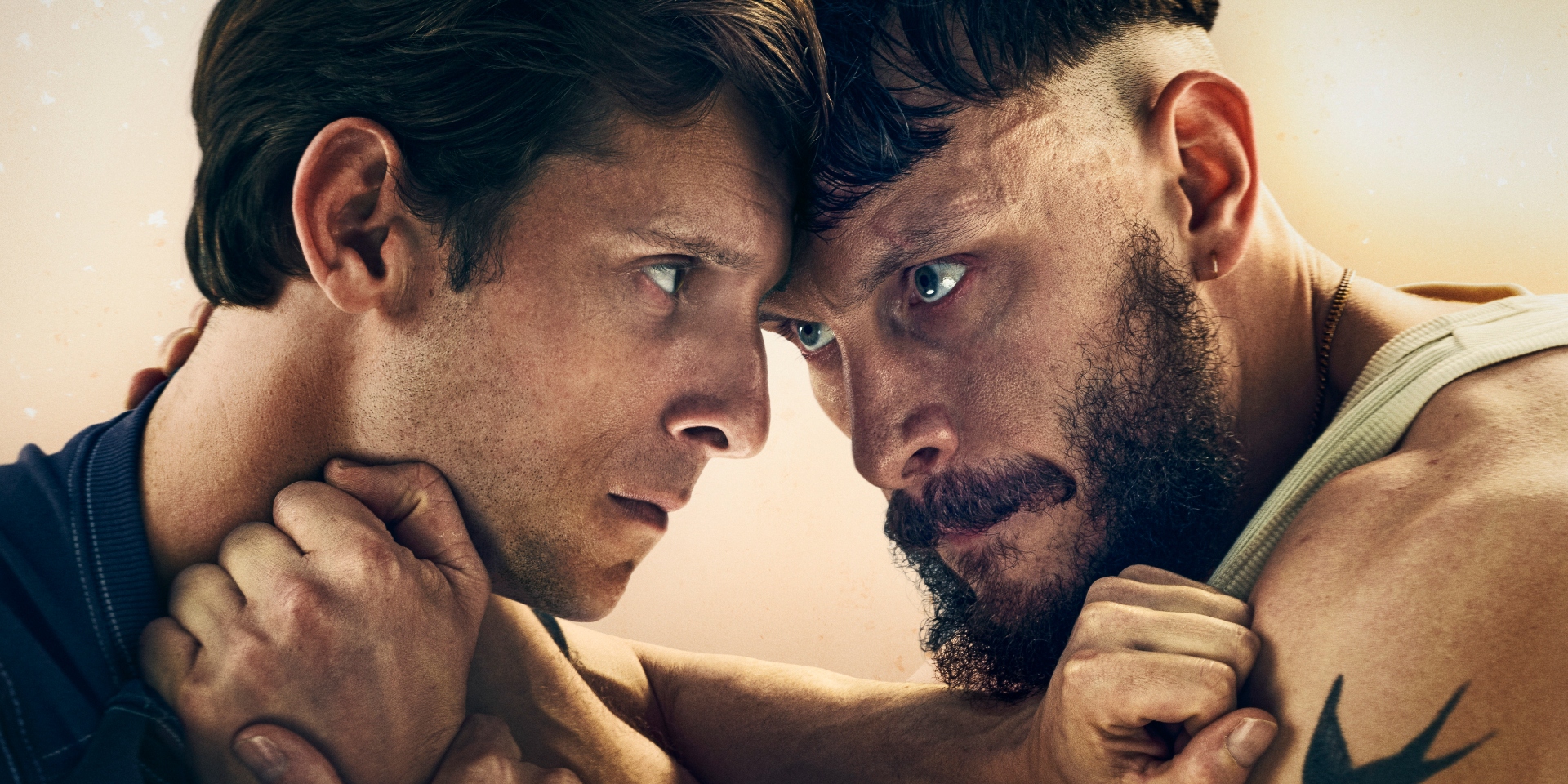 half-man-polbrat | film.org.pl Two men face each other in a tense close-up, gripping each other’s necks and shoulders.