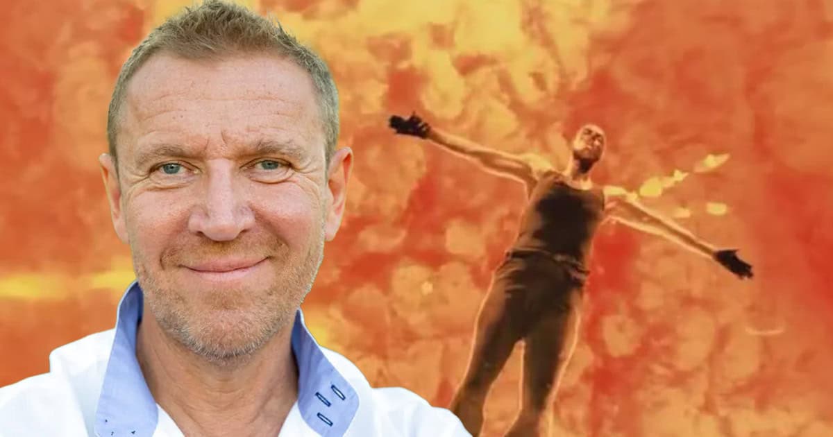Smiling man in a lab coat in the foreground, with a fiery orange background and a person with arms outstretched behind him.