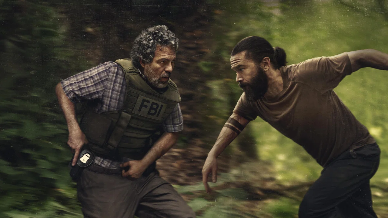 task-grupa-zadaniowa | film.org.pl FBI agent in tactical vest pursues a bearded man through a forest trail.
