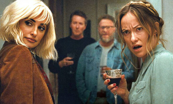 Two women at a party, facing the camera and holding drinks, with two men blurred in the background.