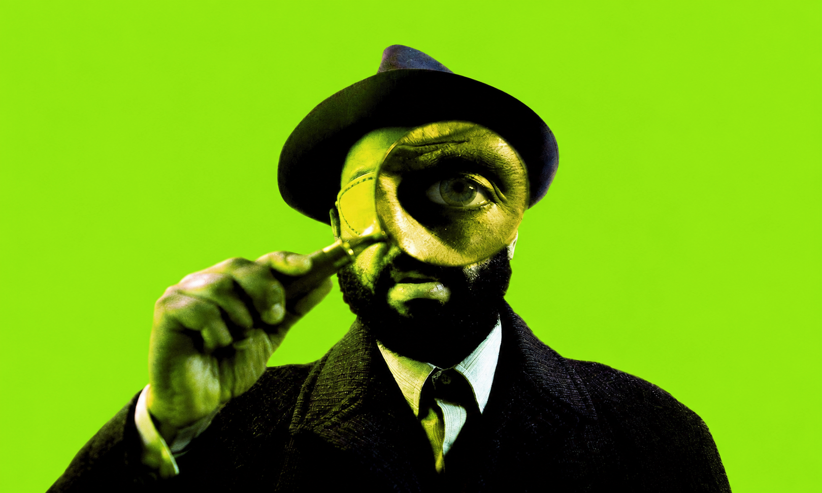 Man in a suit and fedora peers through a magnifying glass against a bright lime green background
