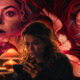 Woman with curly hair on a couch, intently looking at her phone, surrounded by eerie red-toned faces and swirling shapes in a dramatic background.