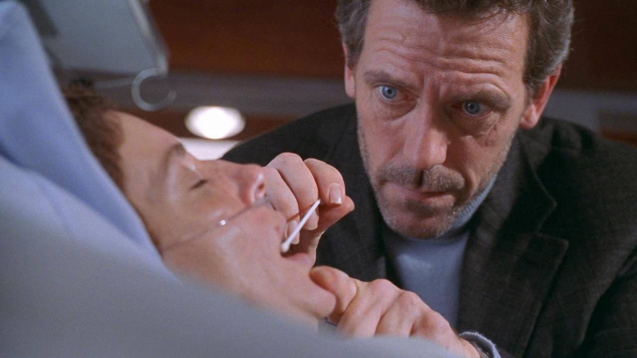 Kadr z serialu Dr House: mężczyzna w ciemnej marynarce pochyla się nad leżącym pacjentem z rurką w nosie. Sherlock Holmes